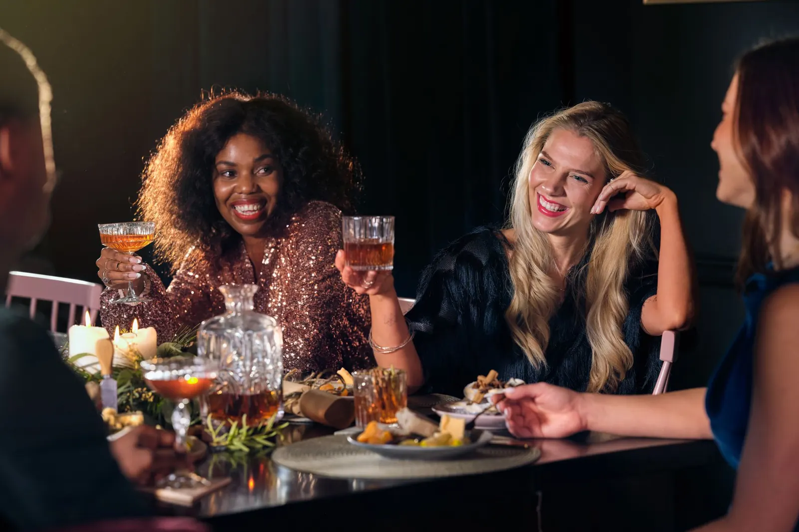Friends laughing around a dinner table