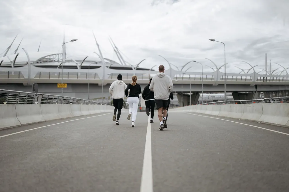 A running club jogging across a city bridge