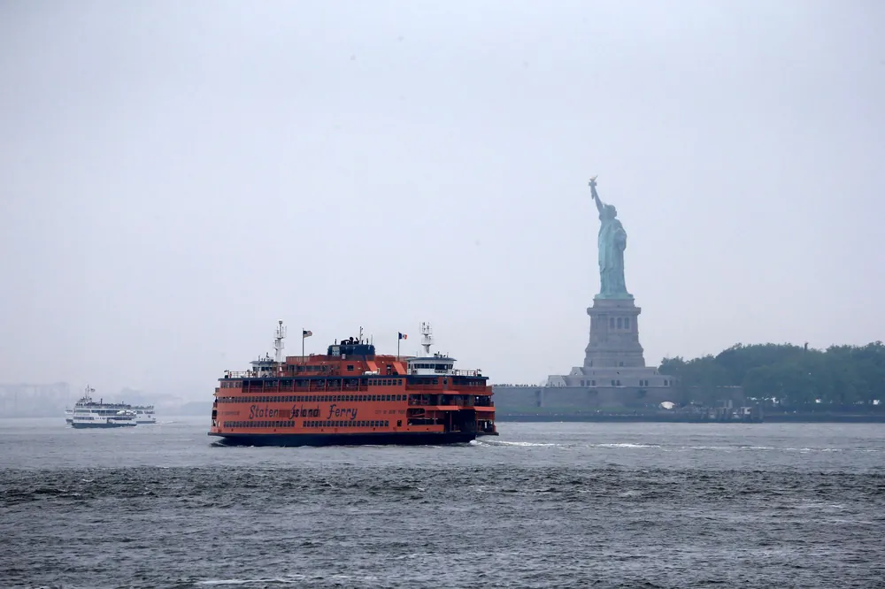 The Staten Island Ferry passing the Statue of Liberty in New York Harbor