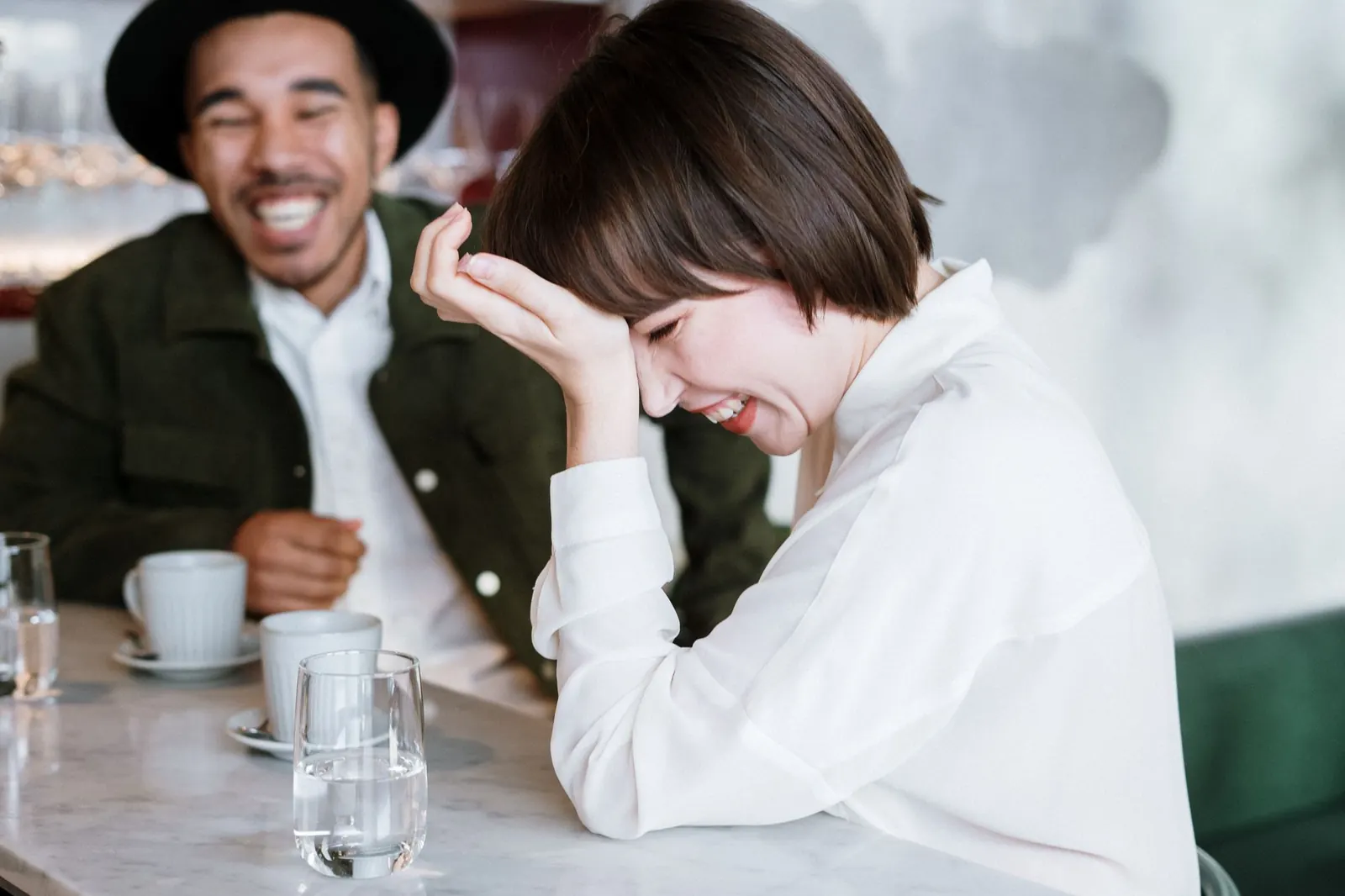 A couple laughing together at a café table