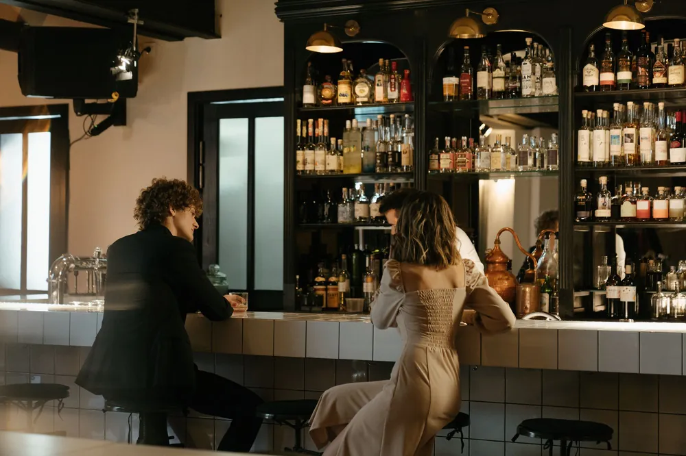 A man and a woman talking at a bar