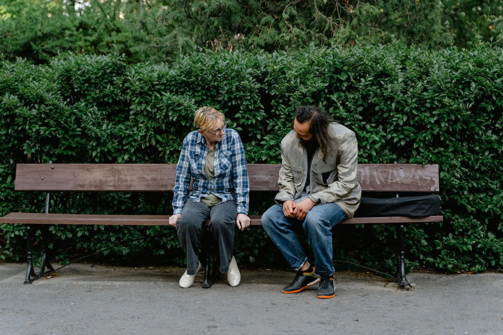 Two people talking on a park bench