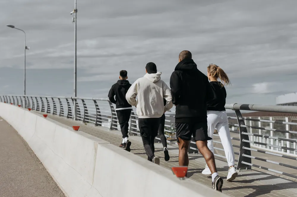 A running group crossing a city bridge