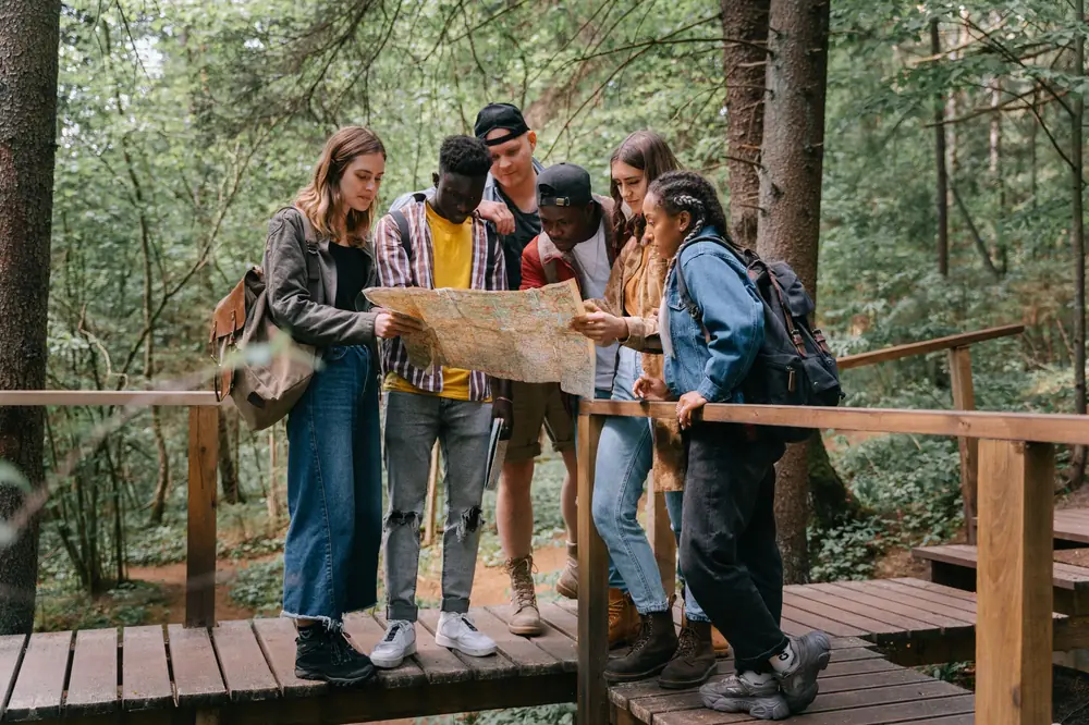 Friends reading a map together on a hiking trail