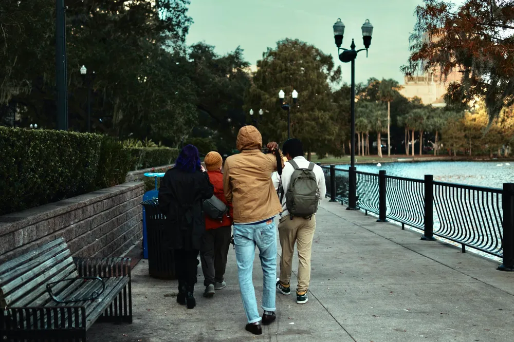 A small group walking along a riverside park path