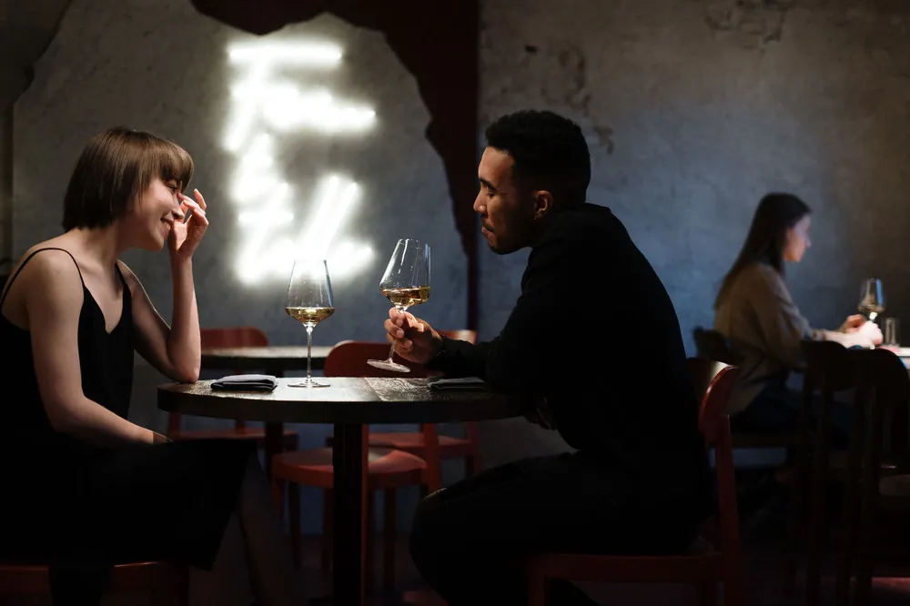 A couple talking over wine at a bar