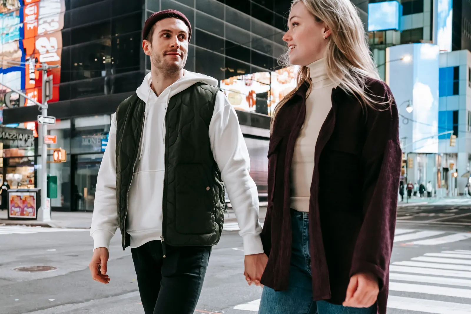 A couple walking hand in hand across a city street