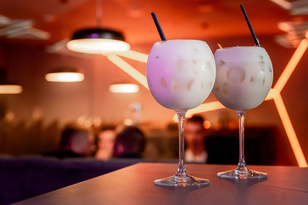 Two cocktails on a bar table in the evening