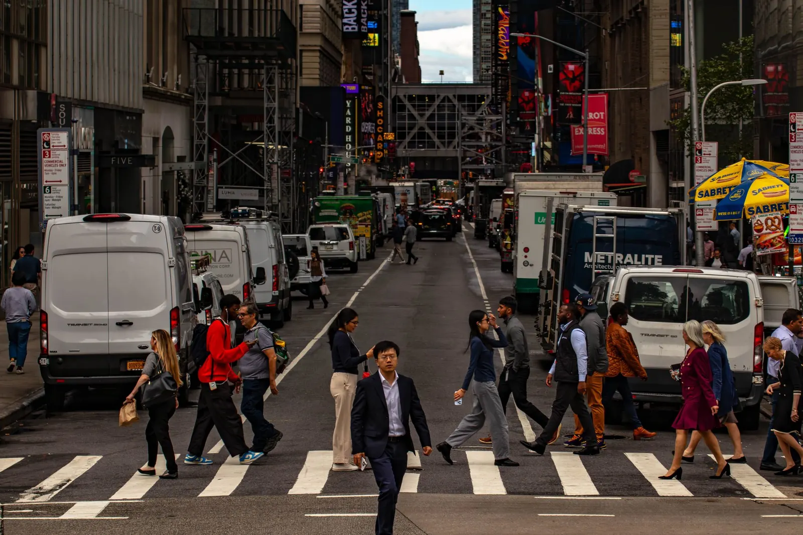 Crowds crossing a busy Manhattan street