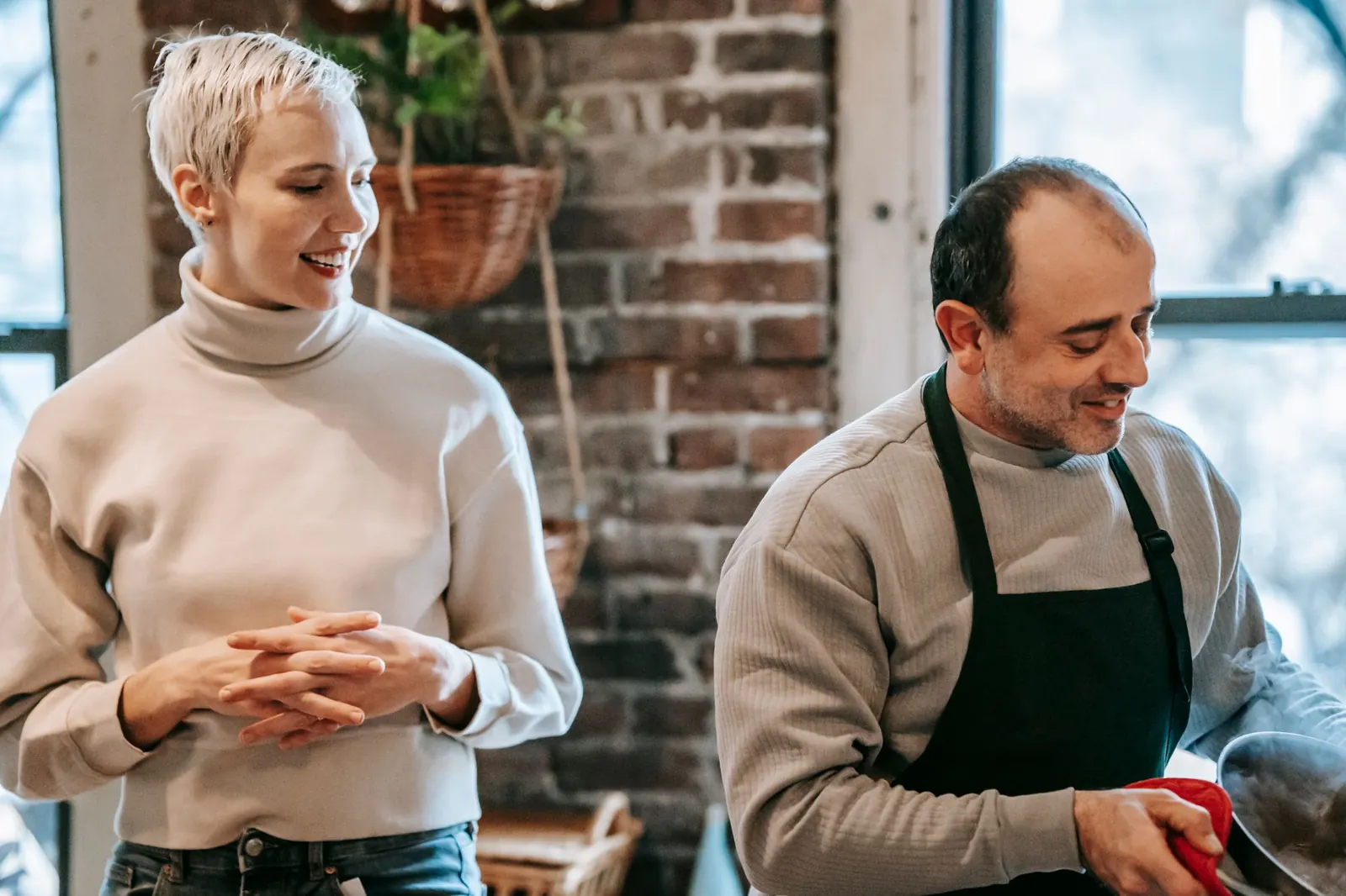 A woman smiling at her partner as he prepares dinner