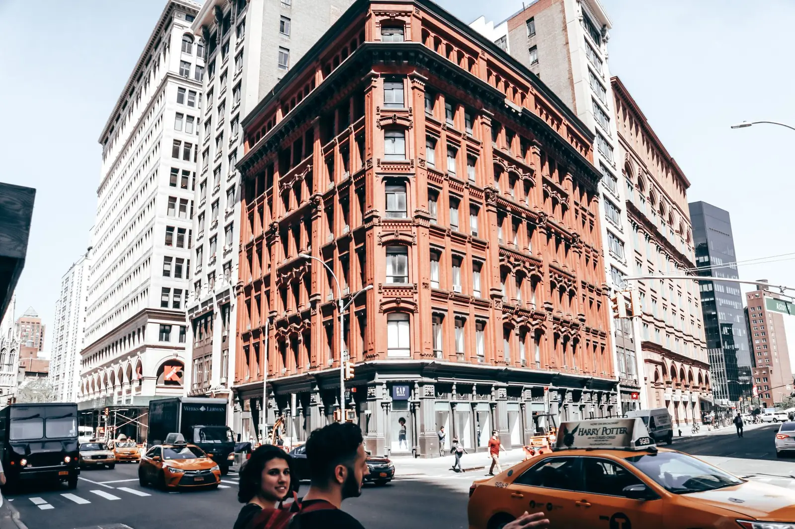 A busy intersection in SoHo, New York, with traffic and historic buildings